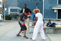 Boxing coach Gilbert Jackson encourages two students sparring