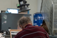 Kenneth sits below vacuum in Laney College printmaking studio